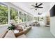 Inviting screened-in porch with wicker furniture, ceiling fans, and views of the wooded backyard at 1642 Reflections Trl, Powder Springs, GA 30127