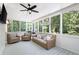 Relaxing screened-in porch featuring comfortable seating, ceiling fan, and lots of natural light at 1642 Reflections Trl, Powder Springs, GA 30127