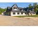 Exterior elevation with a long driveway, showcasing the home's grand design and spacious parking at 1730 Etchison Spur, Loganville, GA 30052