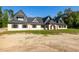 New construction home featuring a light brick facade, dark gray roofing, and a spacious front yard ready for landscaping at 1730 Etchison Spur, Loganville, GA 30052