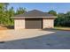 Detached garage with a brick facade, concrete driveway, and ample storage space for vehicles and equipment at 1730 Etchison Spur, Loganville, GA 30052