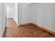 Hallway with decorative herringbone pattern hardwood flooring and fresh white walls at 1730 Etchison Spur, Loganville, GA 30052