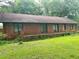 Side view of a brick home featuring a large yard and mature trees at 2641 Old Norcross Rd, Tucker, GA 30084