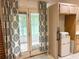 Bright kitchen with sunroom access, mini fridge, floral curtains providing a cozy view of outdoor greenery at 2641 Old Norcross Rd, Tucker, GA 30084