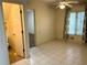 Well-lit room showcasing tile floors, a ceiling fan, and an adjacent hallway, providing ample space at 2641 Old Norcross Rd, Tucker, GA 30084