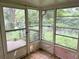 Enclosed porch with large windows offering a view of the overgrown backyard landscape at 2641 Old Norcross Rd, Tucker, GA 30084
