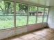 Enclosed sunroom with multiple windows, providing natural light and a view of the overgrown yard at 2641 Old Norcross Rd, Tucker, GA 30084