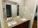 Bathroom showcasing double sinks, wood cabinetry, granite countertop, and a view of a walk-in closet at 284 Regal Dr, Lawrenceville, GA 30046