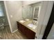 Bathroom featuring double sinks, wood cabinetry, granite countertop, and wood-look floors at 284 Regal Dr, Lawrenceville, GA 30046