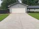 Home featuring an attached two car garage with a white door and a concrete driveway at 284 Regal Dr, Lawrenceville, GA 30046