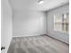 This bedroom features neutral carpet, a window, and crisp, neutral paint at 3717 Blue Goose Ln, Loganville, GA 30052
