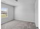 This bedroom features neutral carpet, a window, and crisp, neutral paint at 3717 Blue Goose Ln, Loganville, GA 30052