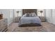 This bedroom features stylish decor with a plush rug, tufted headboard, and bright, natural light at 3717 Blue Goose Ln, Loganville, GA 30052
