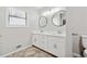 Bright bathroom featuring double sinks, modern lighting and stylish round mirrors at 3753 Eli Dr, Snellville, GA 30039