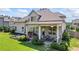 Relax on the covered patio of this beautiful home, featuring comfortable seating, a grill, and manicured landscaping at 3952 Dragon Fly Ln, Loganville, GA 30052