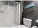 Bathroom with neutral walls, a shower, a toilet, and a decorative shelf at 3952 Dragon Fly Ln, Loganville, GA 30052