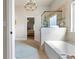 Elegant bathroom with chandelier, a soaking tub and a glass shower at 3952 Dragon Fly Ln, Loganville, GA 30052