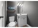 Bathroom with neutral walls, decorative mirror, a toilet, and updated fixtures at 3952 Dragon Fly Ln, Loganville, GA 30052