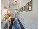Hallway features hardwood floors, wainscoting, decorative lighting, and framed artwork at 3952 Dragon Fly Ln, Loganville, GA 30052