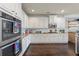 Spacious kitchen features white cabinets, stainless steel appliances, and beautiful hardwood floors at 3952 Dragon Fly Ln, Loganville, GA 30052