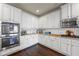 Contemporary kitchen with white cabinets, stainless steel appliances, granite countertops, and hardwood floors at 3952 Dragon Fly Ln, Loganville, GA 30052
