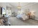 Serene main bedroom with a chandelier, tray ceilings, sitting area, and plush carpet at 3952 Dragon Fly Ln, Loganville, GA 30052