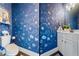 Stylish powder room with bold blue wallpaper and a white vanity at 3952 Dragon Fly Ln, Loganville, GA 30052