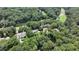 Aerial view showcasing multiple houses with private lake and golf course, surrounded by green trees at 562 Pine Valley Se Rd, Marietta, GA 30067