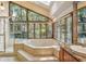 Luxurious bathroom featuring a sunken tub, shower, and many windows for natural light at 562 Pine Valley Se Rd, Marietta, GA 30067
