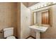Half bath featuring a pedestal sink, decorative mirror, and patterned wallpaper at 562 Pine Valley Se Rd, Marietta, GA 30067