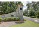 Stone community sign surrounded by flower beds, green lawn, and manicured trees at 562 Pine Valley Se Rd, Marietta, GA 30067