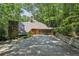 A unique home featuring a stone chimney and a multi-car garage, nestled within a lush wooded landscape at 562 Pine Valley Se Rd, Marietta, GA 30067
