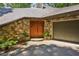 Exterior with stone facade and wooden double door entry and attached garage at 562 Pine Valley Se Rd, Marietta, GA 30067