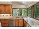 Bright kitchen featuring wood cabinets, granite countertops and windows offering wooded view at 562 Pine Valley Se Rd, Marietta, GA 30067