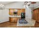 Kitchen with granite countertops, wood cabinets, island with cooktop, and stainless steel appliances at 562 Pine Valley Se Rd, Marietta, GA 30067