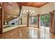 Living room with hardwood floors, wood ceiling, chandelier, and stone fireplace beyond at 562 Pine Valley Se Rd, Marietta, GA 30067