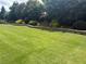 Spacious backyard featuring a manicured lawn with a stone retaining wall, perfect for outdoor activities and relaxation at 848 Rolling Nw Hl, Kennesaw, GA 30152
