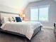 Bright bedroom features a large bed with stylish linens, a window with blinds, and soft carpeting at 848 Rolling Nw Hl, Kennesaw, GA 30152