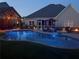 Night view of backyard showcasing a sparkling pool, cozy fire pit, and illuminated cabana, perfect for evening relaxation at 848 Rolling Nw Hl, Kennesaw, GA 30152