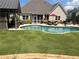 Inviting backyard featuring an in-ground pool, lush lawn, lounge chairs, and an outdoor cabana perfect for relaxation at 848 Rolling Nw Hl, Kennesaw, GA 30152