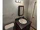This is a bathroom with a dark wood vanity, toilet, mirror and towel rack at 1106 Sharonton Way, Stone Mountain, GA 30083