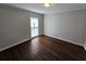 An empty bedroom with hardwood floors and natural light from the window at 1106 Sharonton Way, Stone Mountain, GA 30083