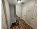 Hallway featuring a staircase with wood railing and doors, plus wood-look flooring at 1106 Sharonton Way, Stone Mountain, GA 30083