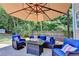 Charming patio featuring outdoor furniture, an umbrella, and a serene backyard setting at 127 Bradshaw Park Dr, Woodstock, GA 30188