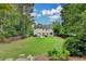 Large, lush backyard with a patio, ample green space, mature trees, and the back of the home at 127 Bradshaw Park Dr, Woodstock, GA 30188