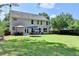 Spacious backyard with a patio seating area, lush lawn, mature trees, and a glimpse of the home's exterior at 127 Bradshaw Park Dr, Woodstock, GA 30188