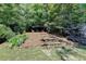 Landscaped backyard with a stone staircase leading to a relaxing seating area, nestled among mature trees at 127 Bradshaw Park Dr, Woodstock, GA 30188