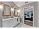 Bathroom with double marble vanity, fashionable gold-framed mirrors and marble flooring at 127 Bradshaw Park Dr, Woodstock, GA 30188