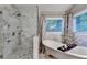 Elegant primary bathroom featuring a glass enclosed shower, a garden tub and marble accents at 127 Bradshaw Park Dr, Woodstock, GA 30188