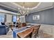 Elegant dining room with a large wooden table, stylish chandelier, and views into the living room at 127 Bradshaw Park Dr, Woodstock, GA 30188